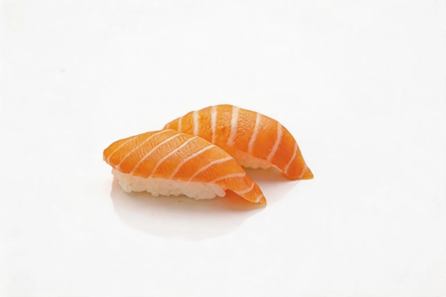 Two salmon nigiri placed side by side on a white background